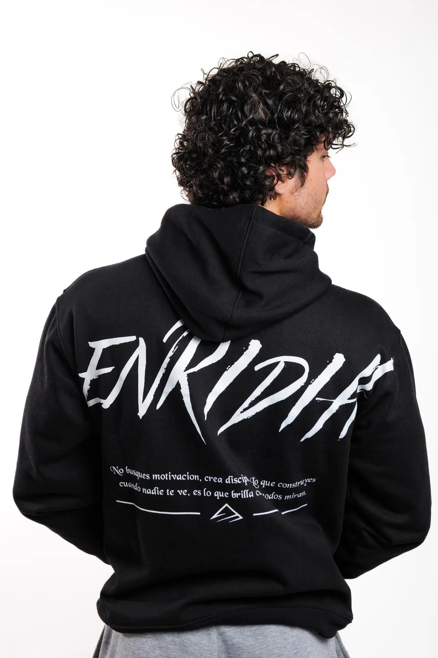 Espalda del hoodie Reborn To Dominate en negro, con el lettering trazado a mano