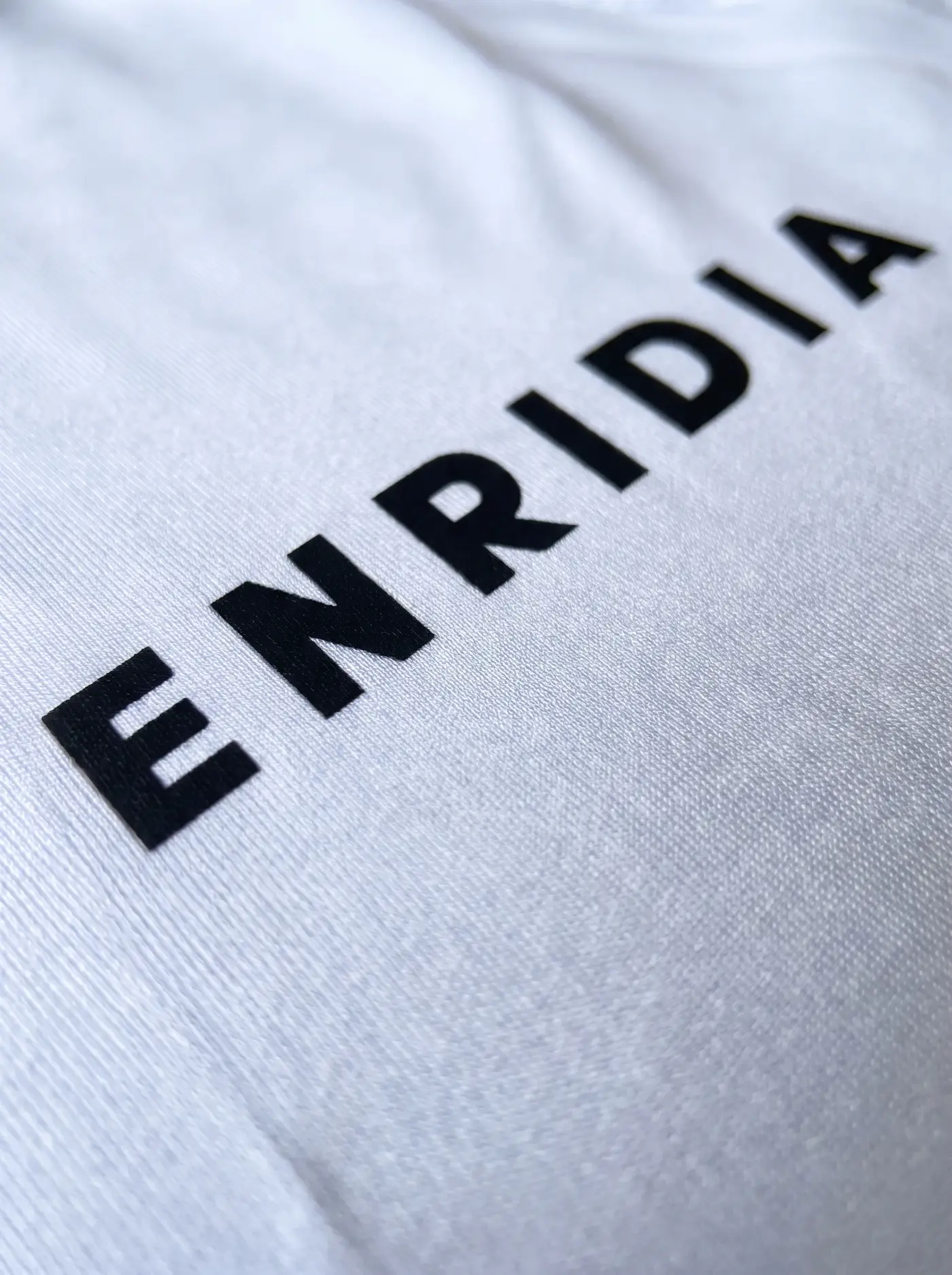 Detalle del logotipo Enridia sobre el long sleeve blanco